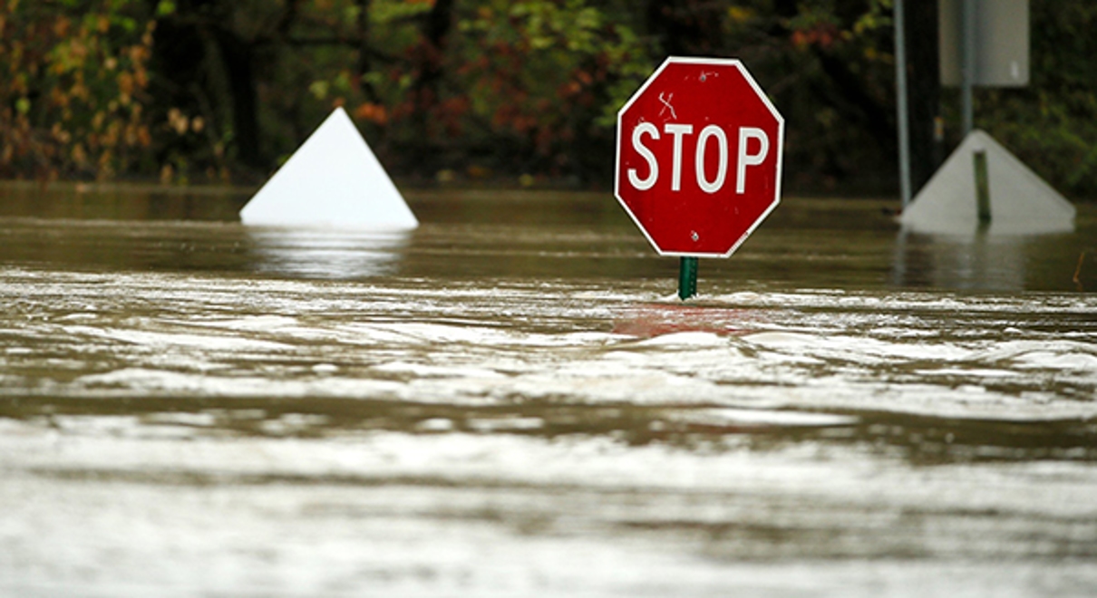A stop sign stands in a street that is flooded
