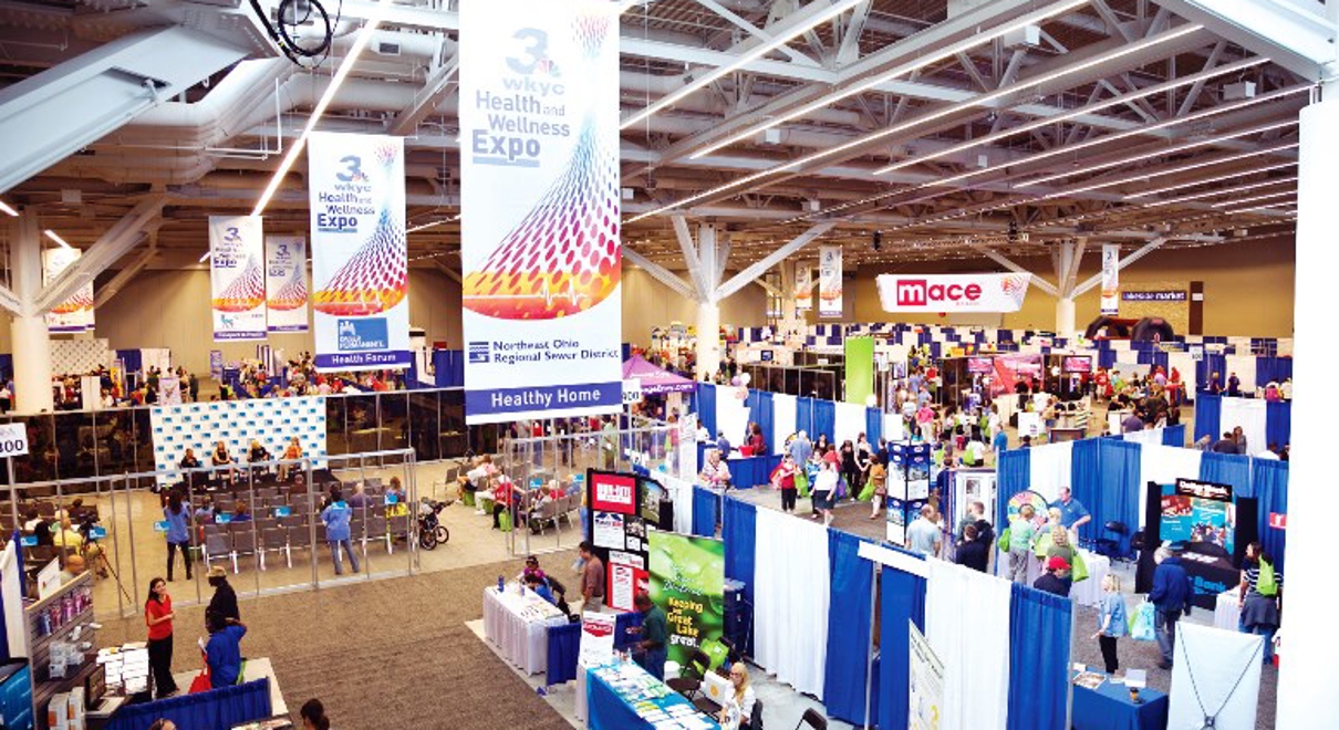 An expo has signs hanging to help direct traffic