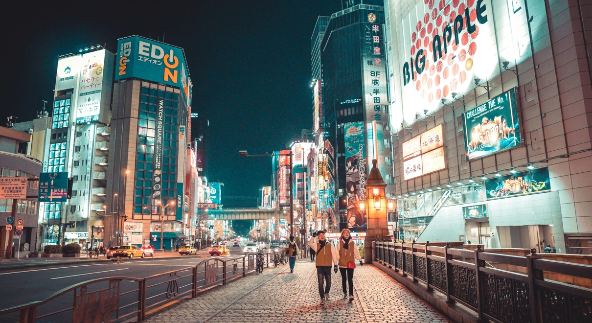 two women walking in the city at night