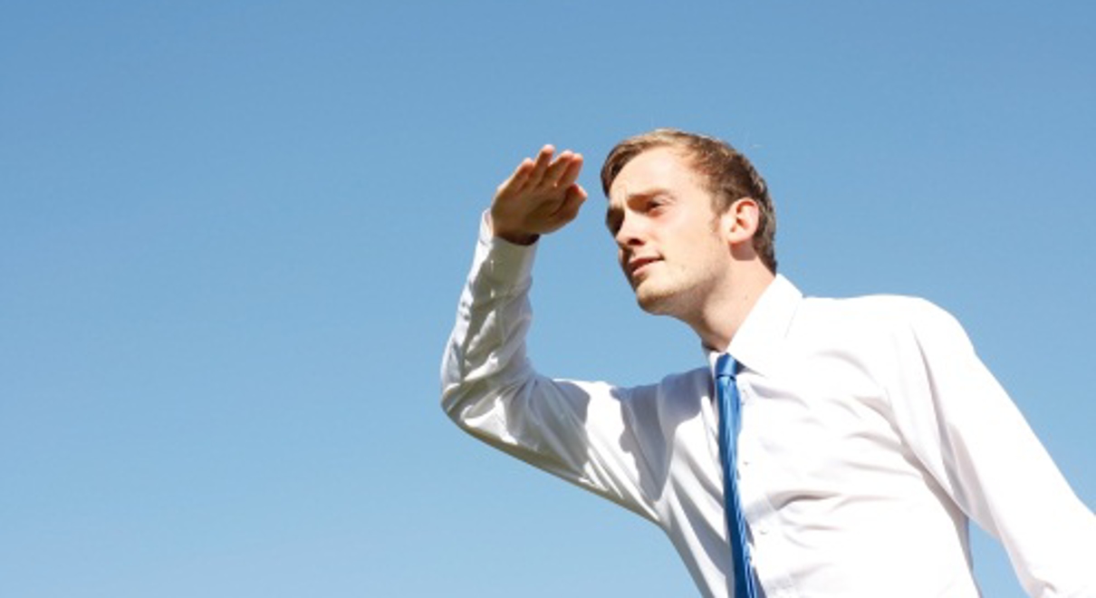 A stock photo of a man in a suit looking for something in the distance
