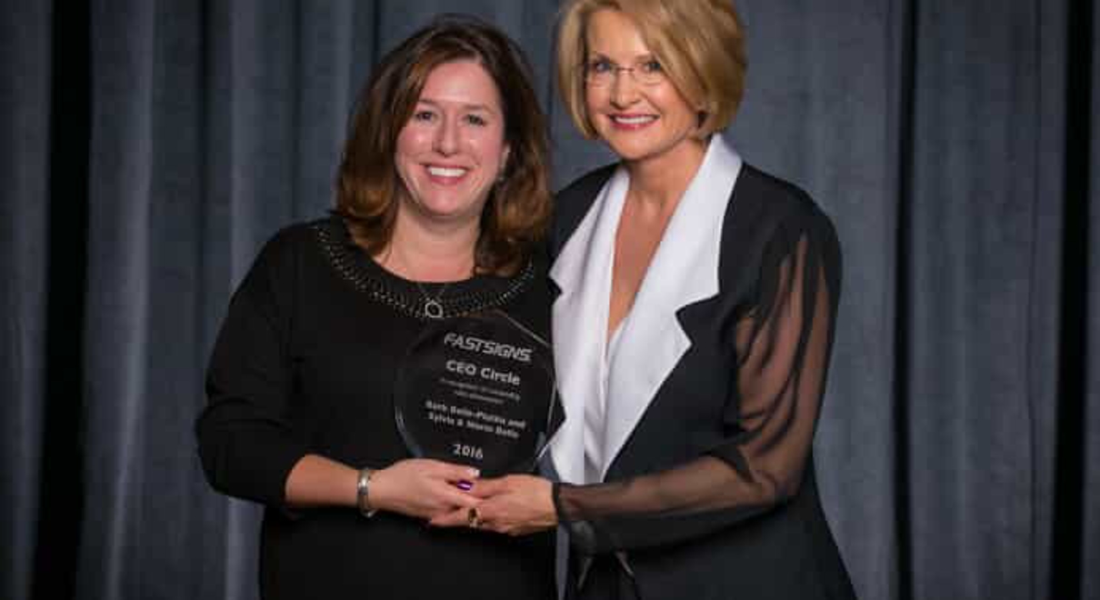 L-R: Barb Belle-Plutko and FASTSIGNS CEO Catherine Monson with a CEO Award