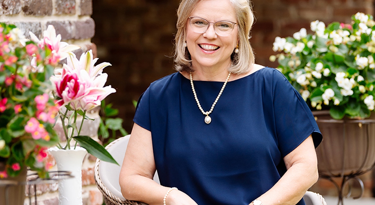 Pauline C McKean sits outside by some flowers