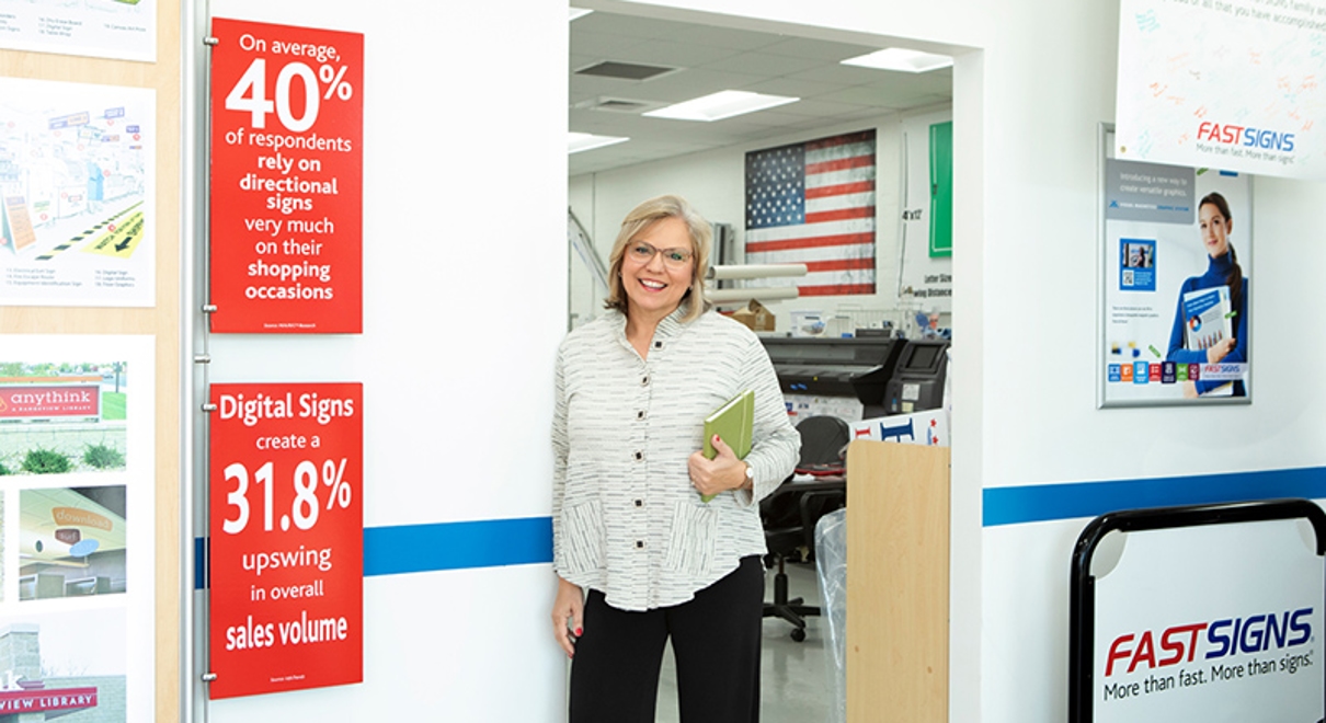 pauline mckean stands in her fastsigns center
