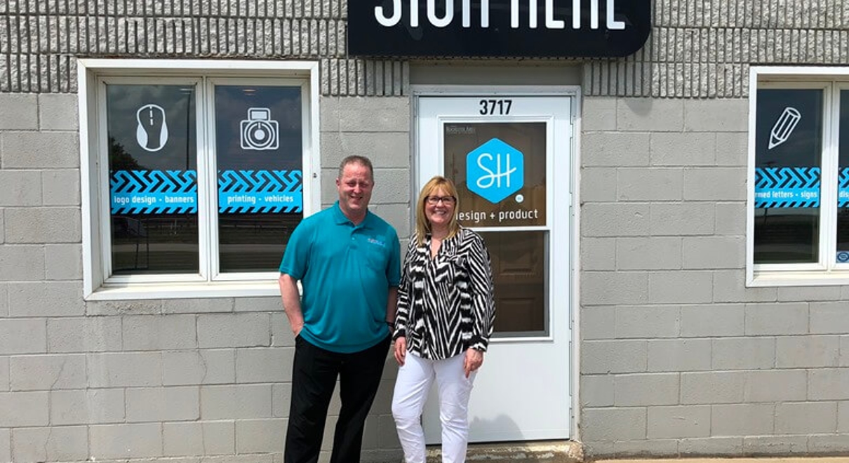 Jodi Babcock (right), former owner of Sign Here and new CFO for FASTSIGNS of Rochester, poses with Andy Anderson (left), owner of FASTSIGNS of Rochester.