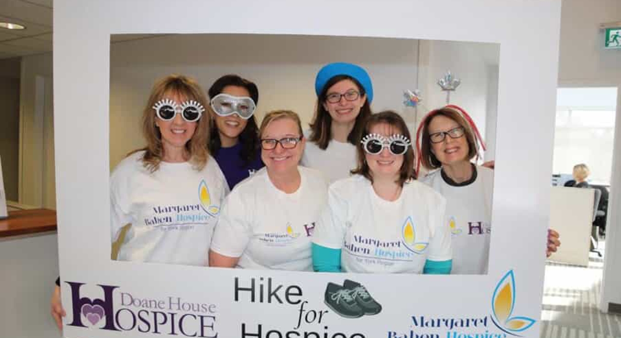 FASTSIGNS of Newmarket employees with a photo frame for Hike for Hospice