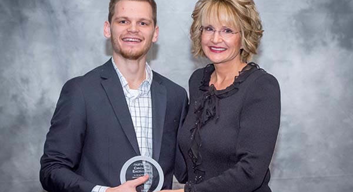 Matt De Luca (left) received the Circle of Excellence Award at the 2018 FASTSIGNS Convention presented by Catherine Monson (right), CEO of FASTSIGNS International, Inc.