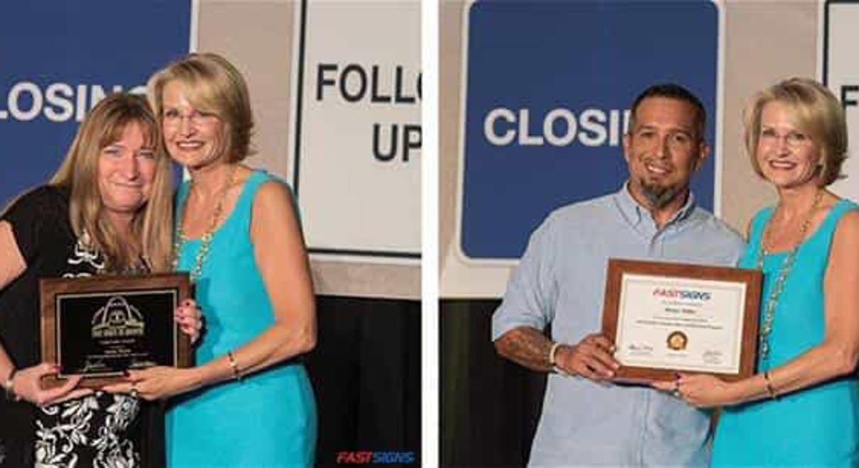 Two FASTSIGNS employees receive awards from Catherine Monson