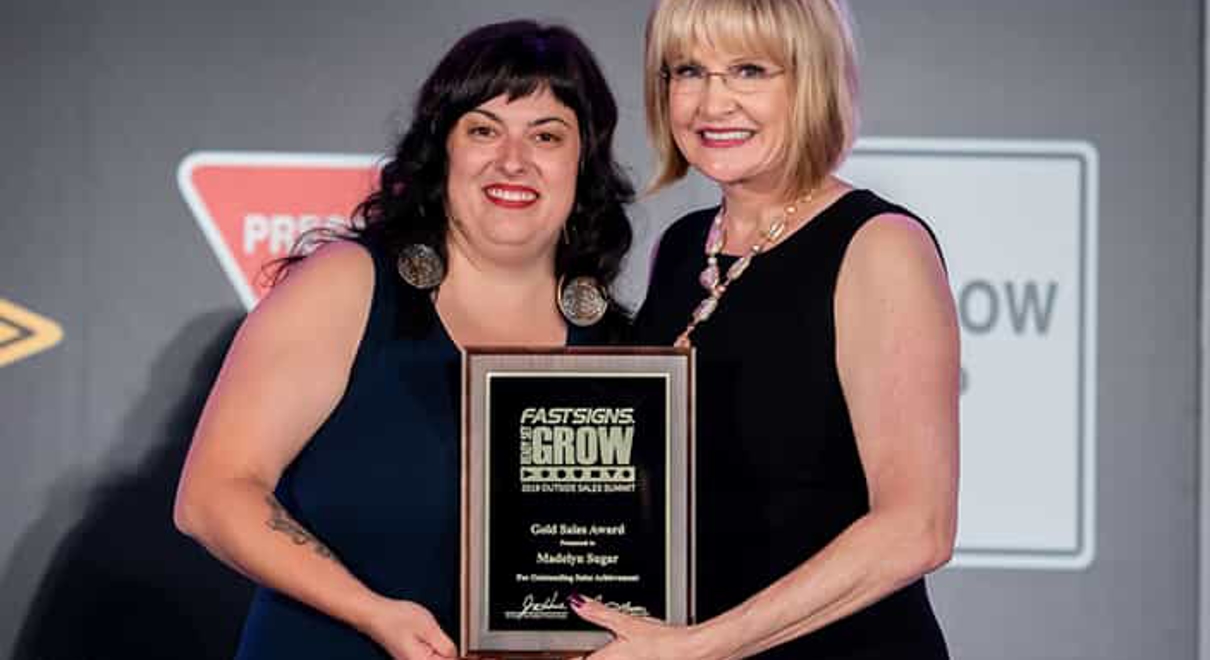 Madelyn Sugar receives the Gold Sales Award from Catherine Monson