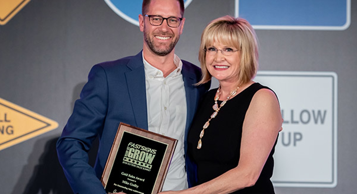 Mike Godby receives the Gold Sales Award from Catherine Monson