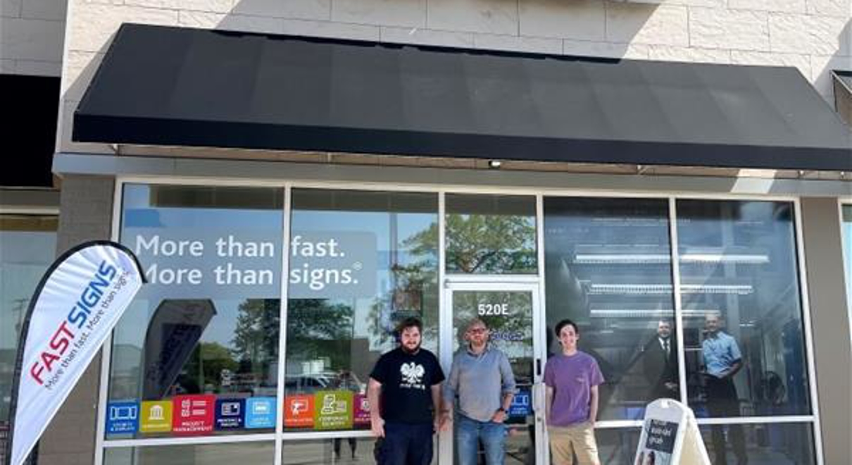 three men standing outside of FASTSIGNS of Addison center