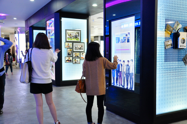 A display at a trade show uses a digital touch screen to allow users to engage with the brand
