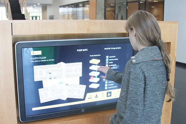 A woman uses an interactive digital sign to help find her way around