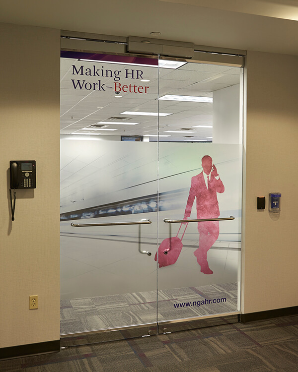 An office glass door has graphics to indicate it leads to HR