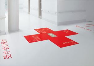 A floor graphic of a red plus in a Japanese hospital