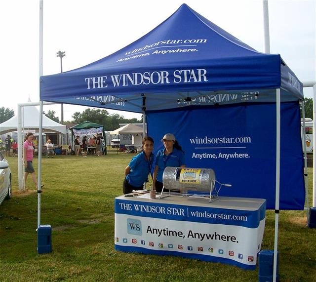 The Windsor Star has a tent at a trade show full of branded materials and signs