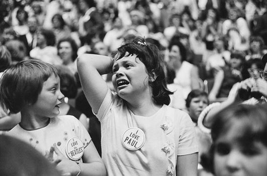 Excited fans wear buttons showing support for the Beatles