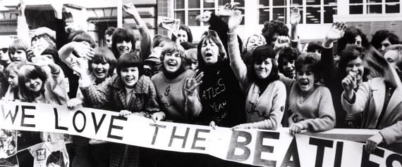 Fans of The Beatles hold a sign that says "We Love the Beatles"