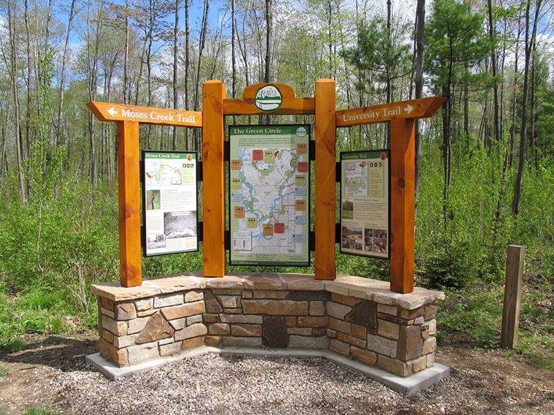 A sign in a hiking trail provides a map and information about the various trails
