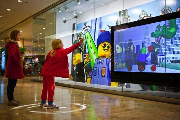 A LEGO store uses an interactive digital POP sign to advertise to potential customers walking by