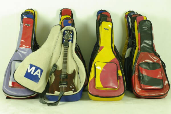 A collection of guitar cases are made with upcycled marketing materials