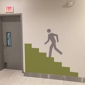 A wall graphic indicates an exit