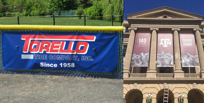 A banner hangs over a fence and draped from the side of a college building's walls