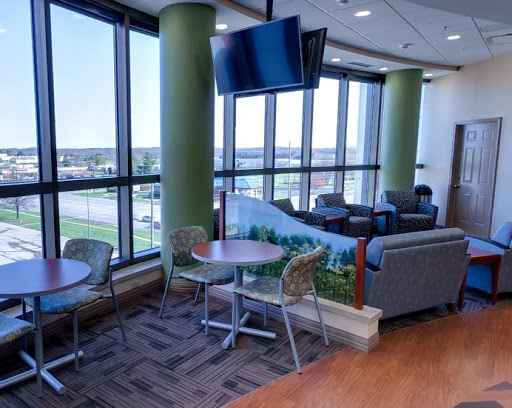 An office space features screens hanging from the ceiling and a decorated barrier between sections