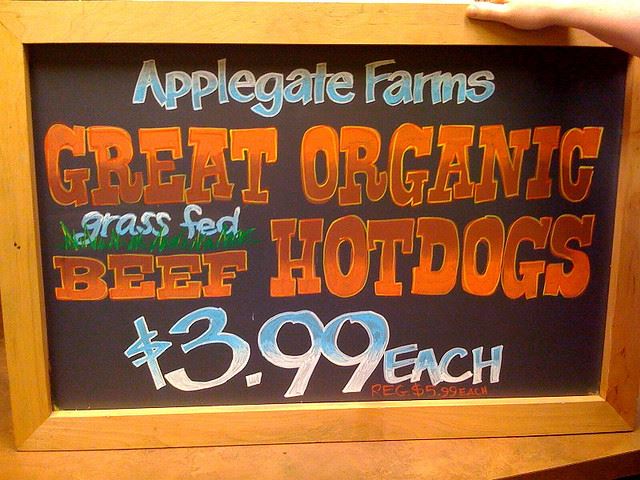 A hand painted sign advertising hotdogs
