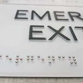 An emergency exit sign features braille