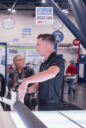 Signs hang from the ceiling at a trade show to identify aisles