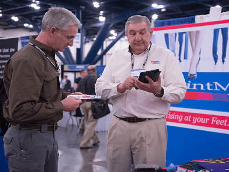 Attendees look at flyers with a company's information on it