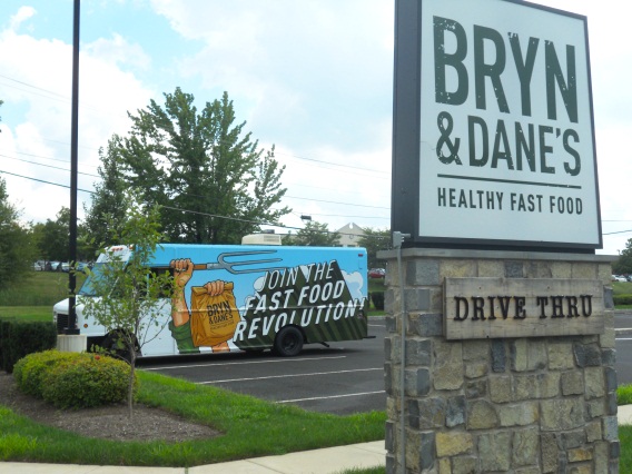 A vehicle wrapped in graphics advertises for a restaurant