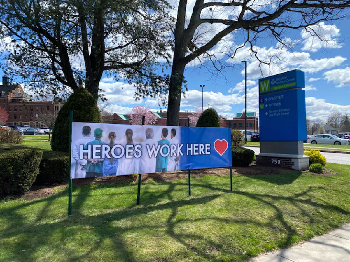 large lawn sign outside of a hospital that reads "heroes work here"