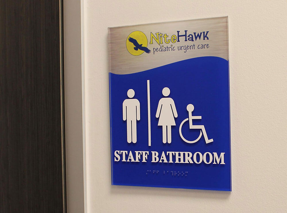 blue bathroom regulatory sign with braille