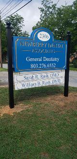 New berry dental Associates signage  on the side of the road with wires and trees on the background
