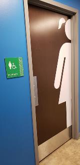 Girls restroom with a drawing of a girl on the door