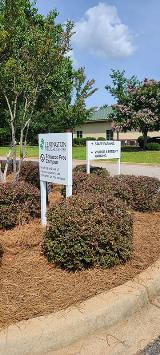 Lexington Medical center two signage surrounded by flowers and trees