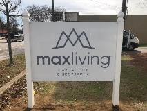 Max living Signage with a building on the back and car