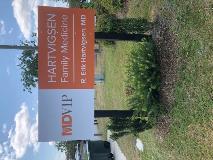 MD VIP medical signage with plants on the side and garbage can