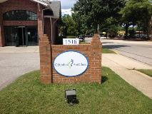Columbia foot clinic signage on the brick statue by the side of the road with building and tree at the back