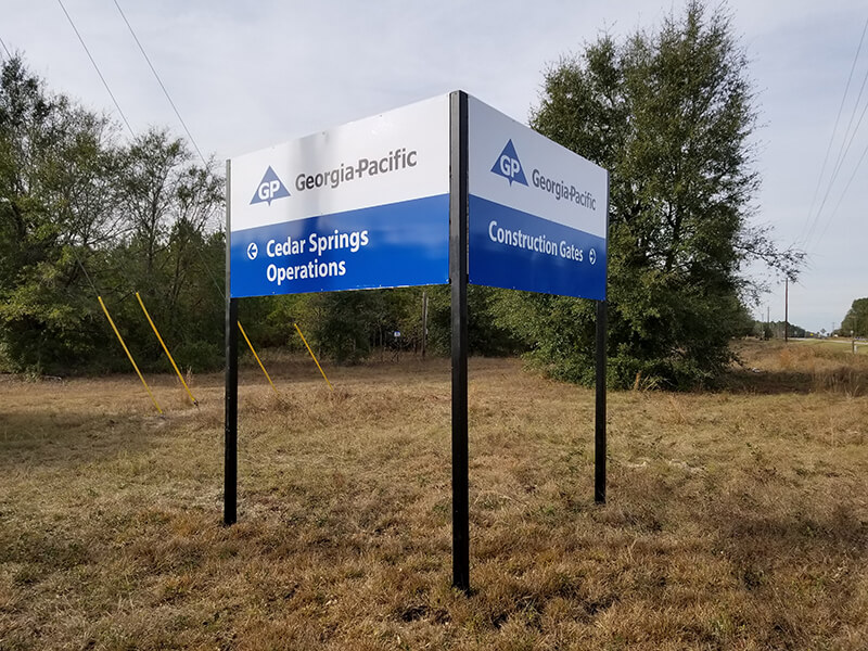 Georgia Pacific Signage with directions in a empty lot with tress and plants