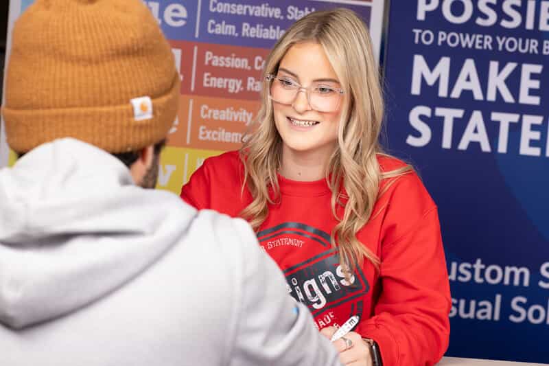 An image of Miranda with a customer at the sales counter.