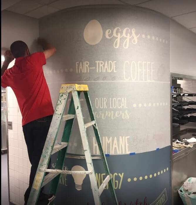 Man working on the custom decal on the column