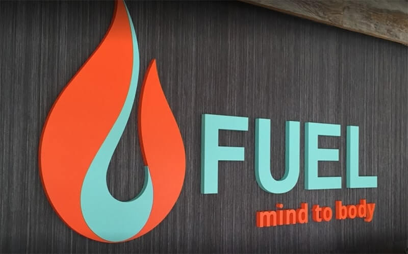 Orange and sky blue Fuel custom decal on the wood wall