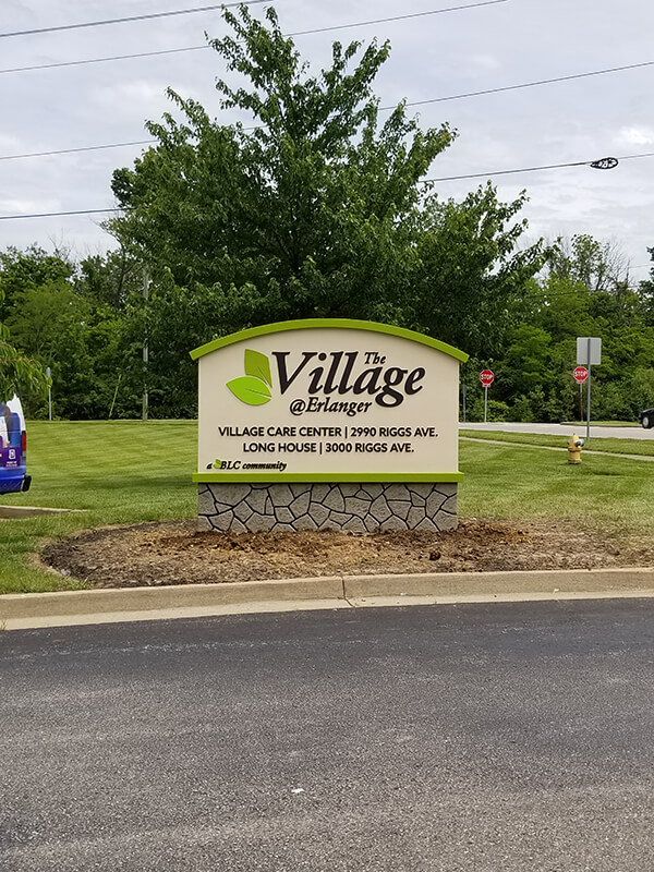 Green and white the village monument signage