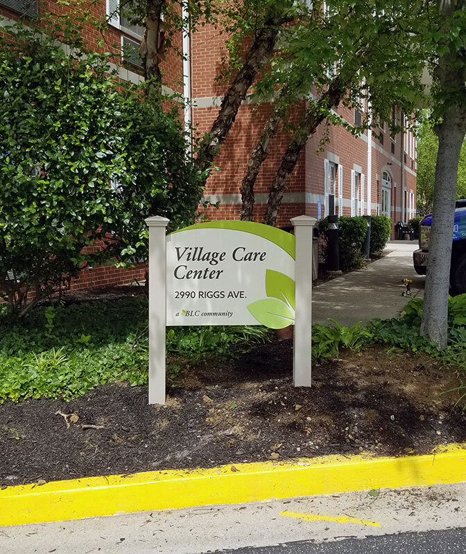 Green and white village care exterior signage