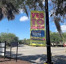 Hanging signage  on the pole outside the store