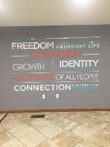 Custom decals on the gray wall along the hallway of the office