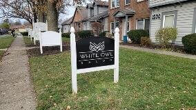 White Owl salon custom signage in front of the houses and on the side of the foot pathway