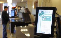 Gift card advertisement in tablet with man and woman in the background